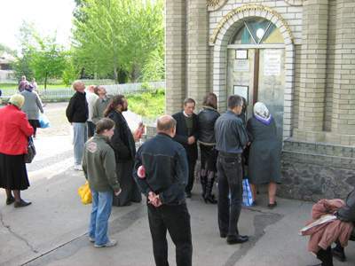 Перед дверями часовни-купальни очередь, паломники заходят туда с молитвами. Первыми - женщины и дети, последними - мужчины