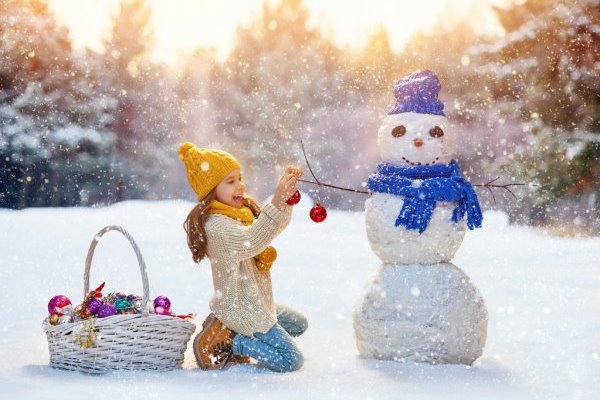 girl playing with a snowman