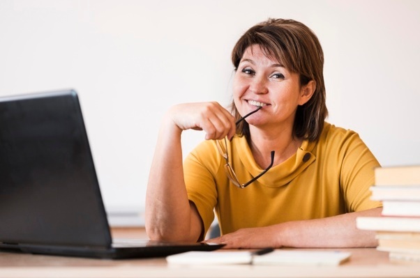 teacher with laptop sitting at desk 