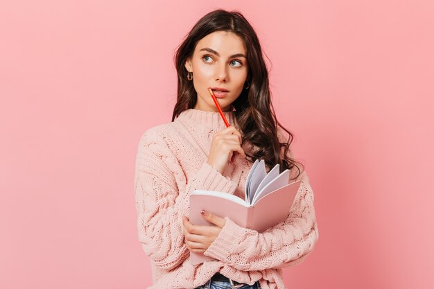 dark haired woman in knitted sweater looks up thoughtfully lady thinks what to write in new book 197531 13537