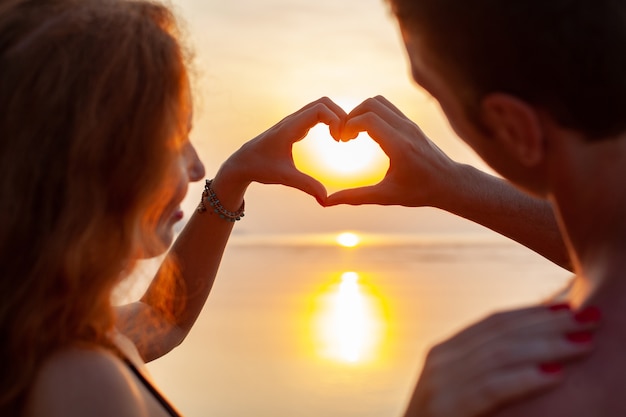 young sexy romantic couple in love happy on summer beach together having fun wearing swim suits showing heart sign on sundet 285396 6545